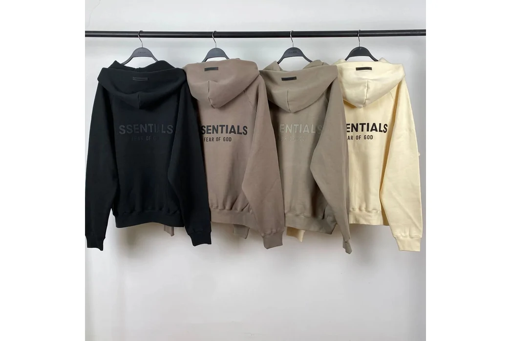 Four hoodies hanging on a rail, photographed in a room rather than rendered